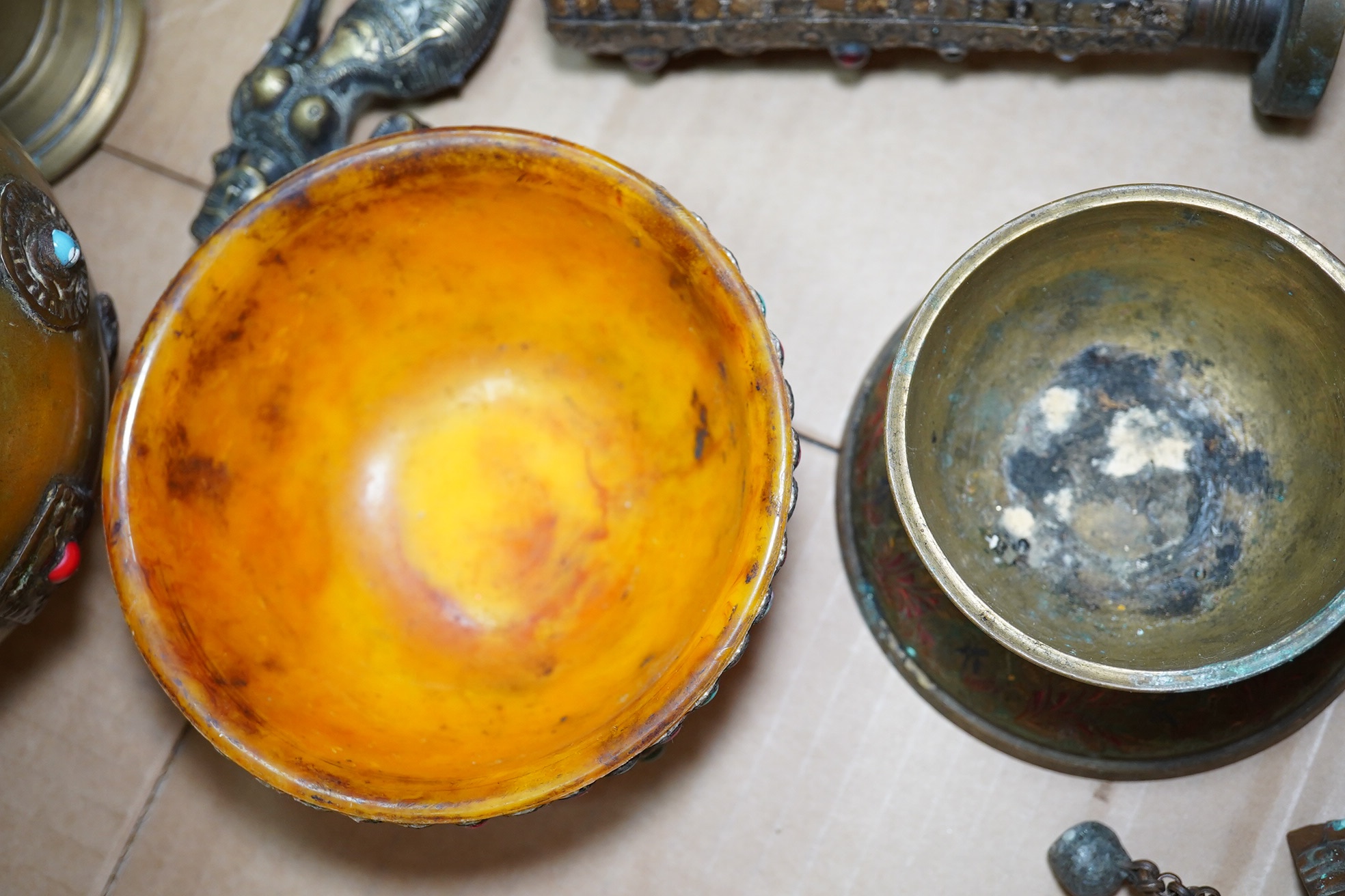 A group of Tibetan brass and mixed metal artefacts to include a brass vase with cabochon inset stones and figures of deities, largest 22cm high. Condition - mostly fair